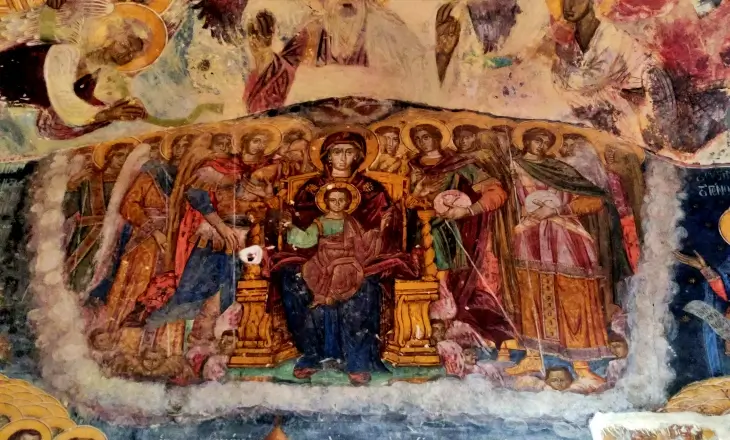 Sümela Manastırı kaya kilisesindeki tahtta oturan Hz. Meryem ve Çocuk İsa freski; çevresinde meleklerle betimlenen detaylı Bizans dönemi ikonografisi.